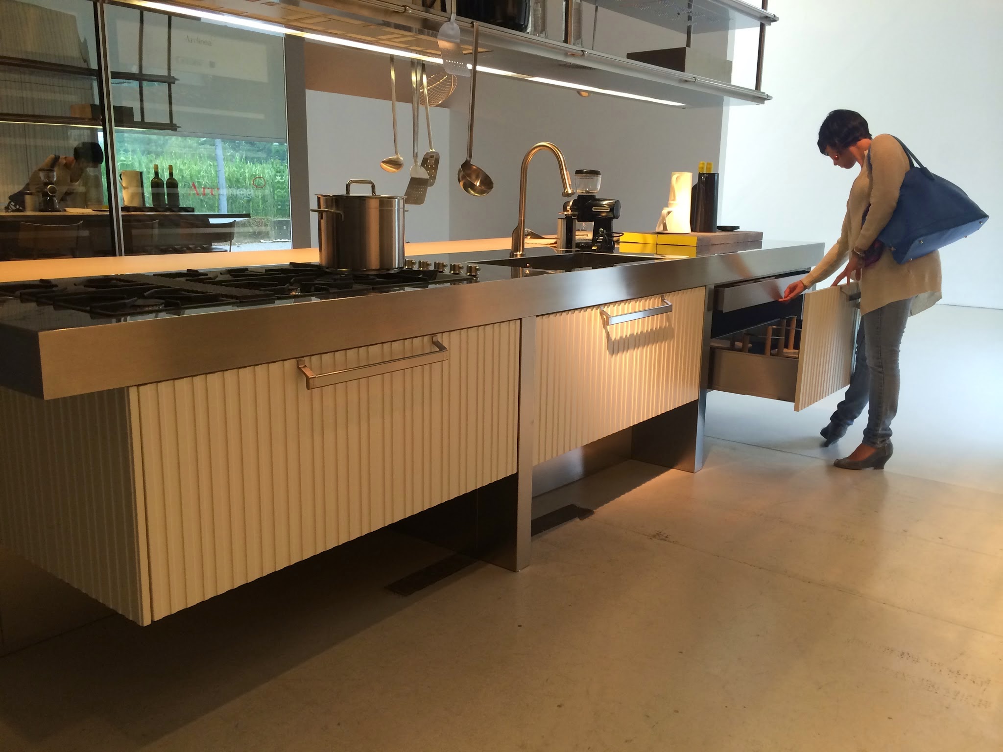 Una visitatrice osserva i dettagli di una cucina in esposizione