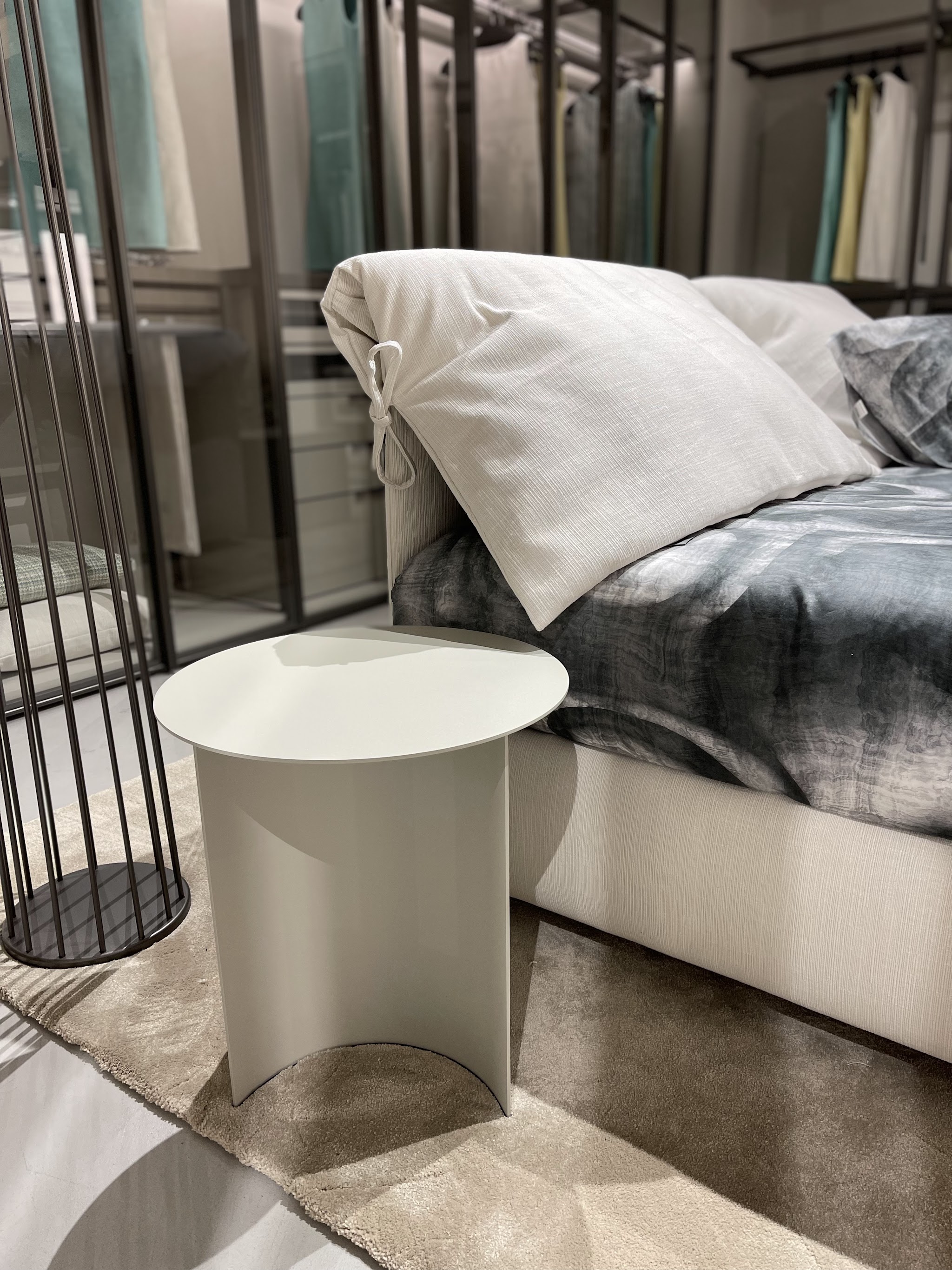 Letto imbottito, comodino e lampada nella zona notte dello showroom